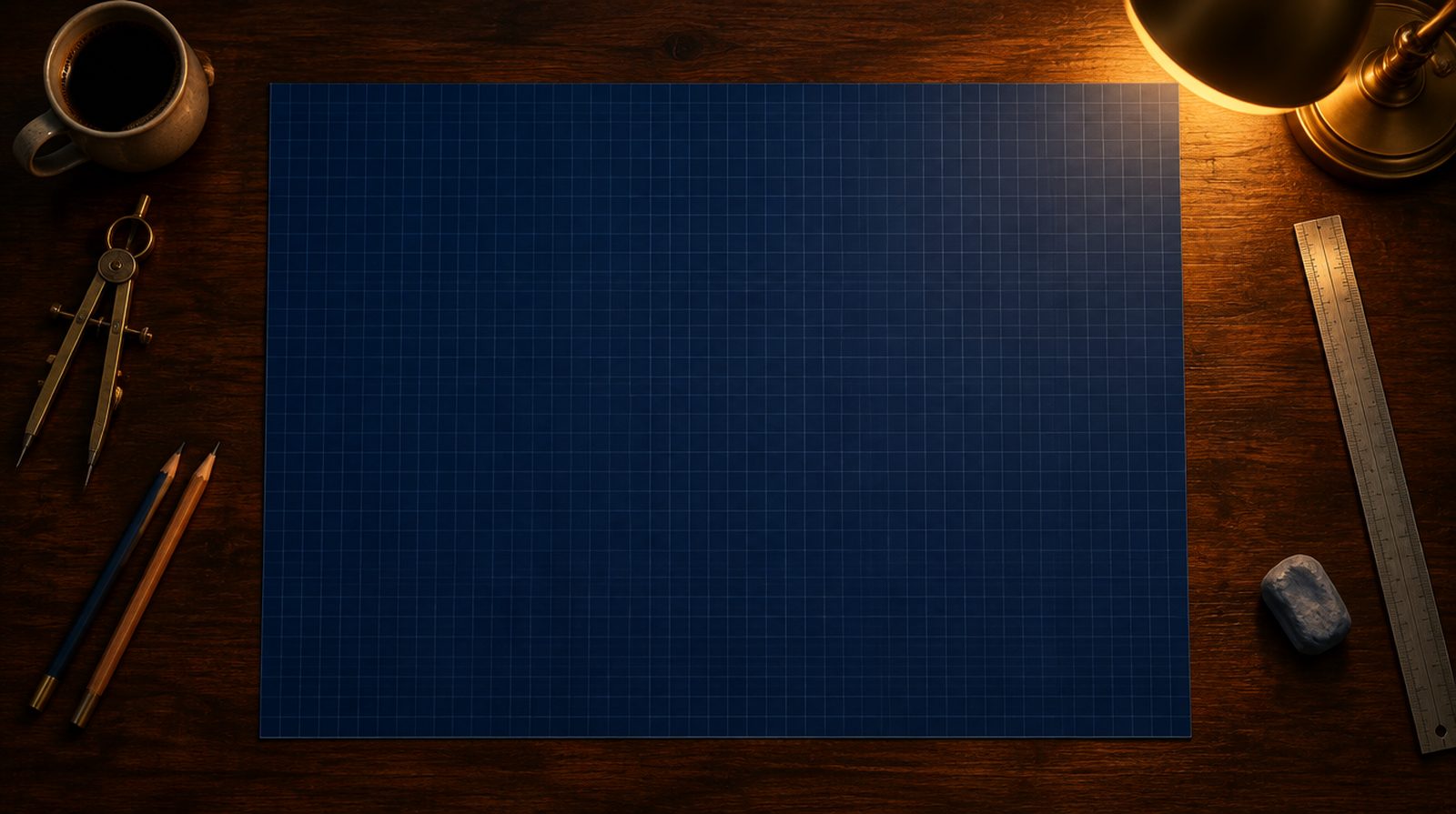 A walnut drafting table at night under a brass lamp, with a large sheet of navy blueprint paper